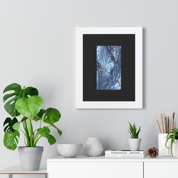 Framed artwork above shelf with plants.
