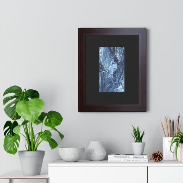 Framed abstract art above modern white dresser.